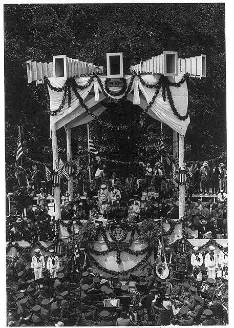 [Charles Lindbergh on podium on Washington Monument grounds during his Wash., D.C. reception; Army band in foreground]: Lindbergh speaking