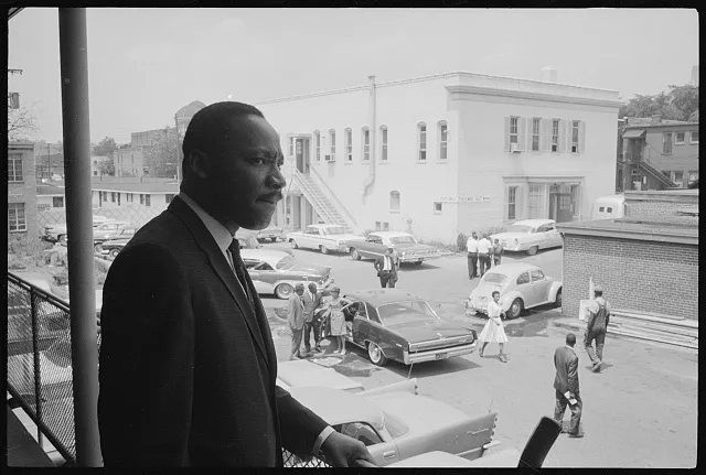 [Civil rights leader Martin Luther King standing on a balcony at the A. G. Gaston Motel overlooking a parking lot, during the Birmingham Campaign, Birmingham, Alabama]
