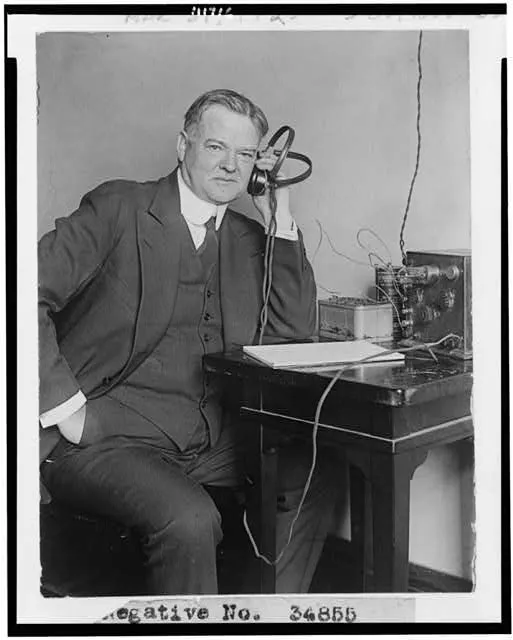 [Herbert Hoover, three-quarter length portrait, seated, facing slightly right, listening to radio]