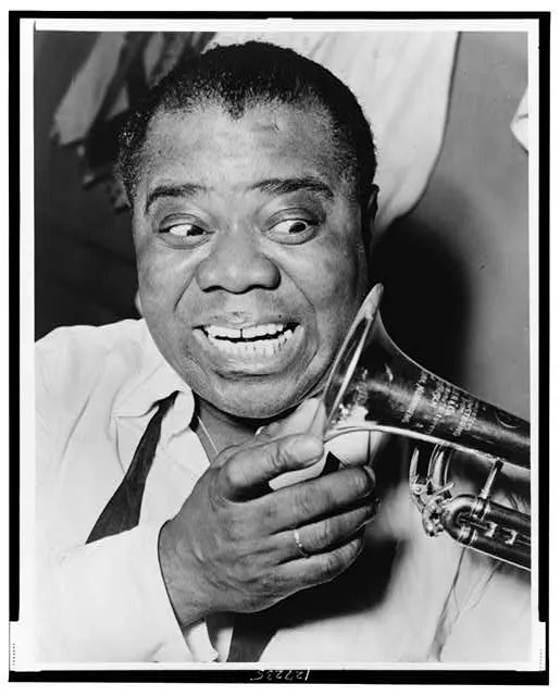 [Louis Armstrong, head-and-shoulders portrait, facing front, looking at trumpet]