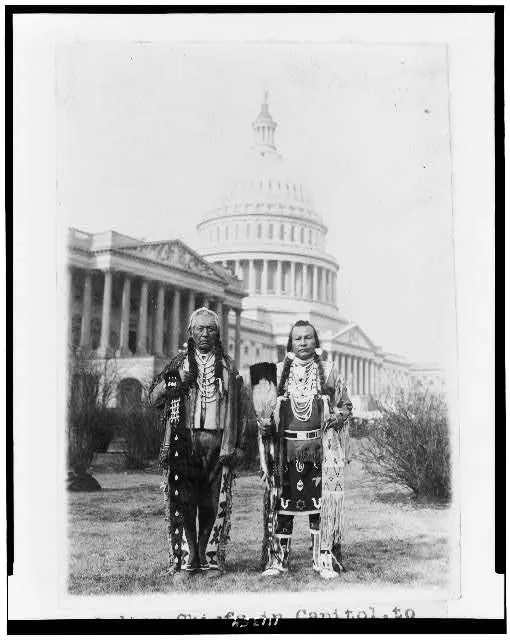 [Native American chiefs Frank Seelatse and Chief Jimmy Noah Saluskin of the Yakama tribe posed, full-length portrait, standing, facing front, with the U.S. Capitol behind them]