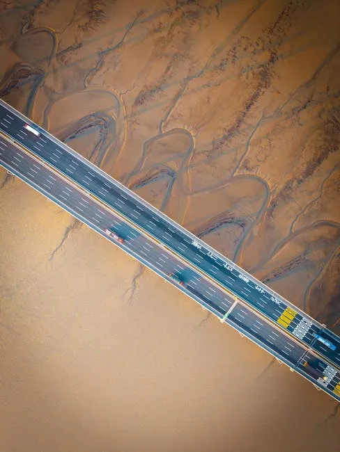 Aerial shot of a modern bridge over a muddy river delta showcasing natural patterns.
