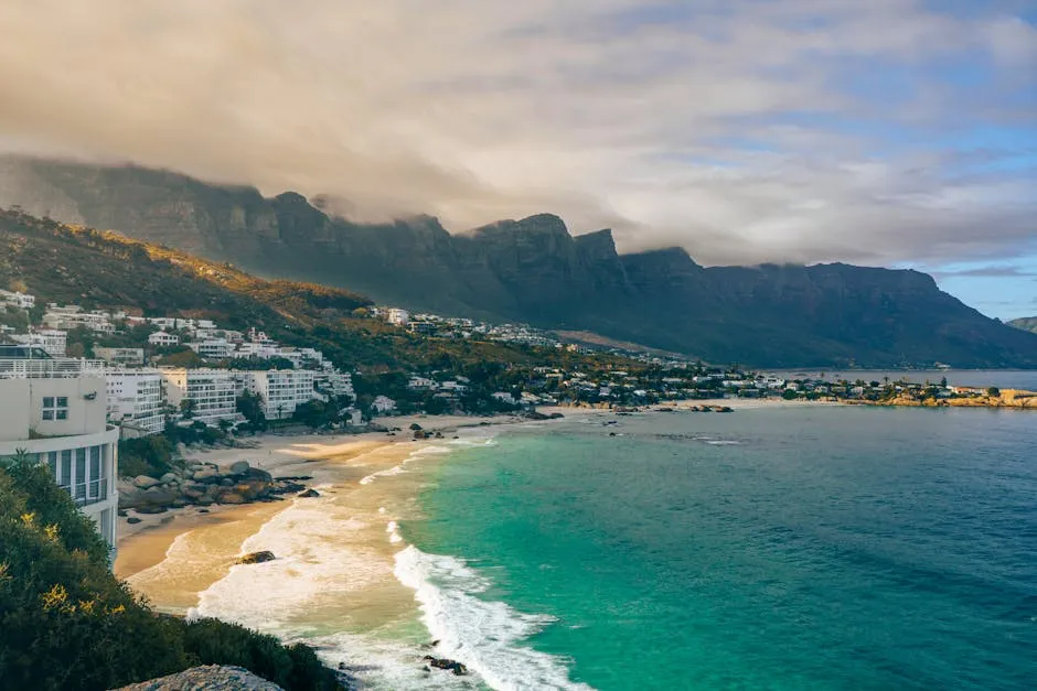 Beautiful coastal view of Cape Town with mountains and beach under dramatic sky.