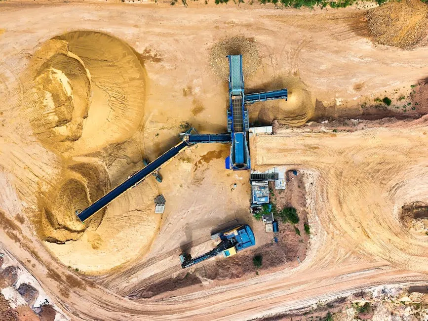 Drone shot of a sand quarry with conveyor belts and machinery in operation.