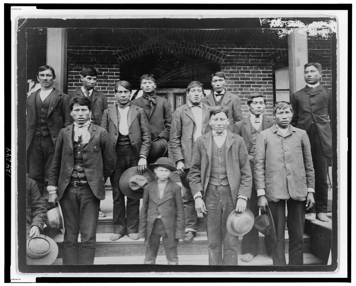 Native American men and a boy posed outside of Carlisle Indian School LCCN99471846
