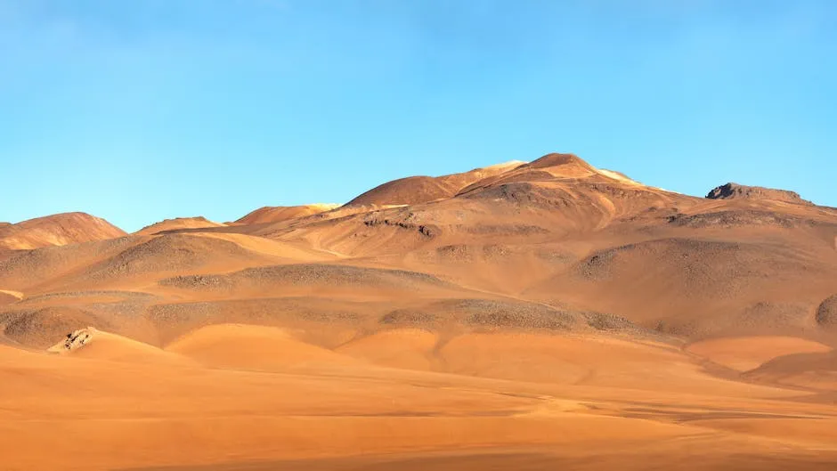 Scenic view of Atacama Desert dunes and hills under the clear blue sky in Chile's Andes.