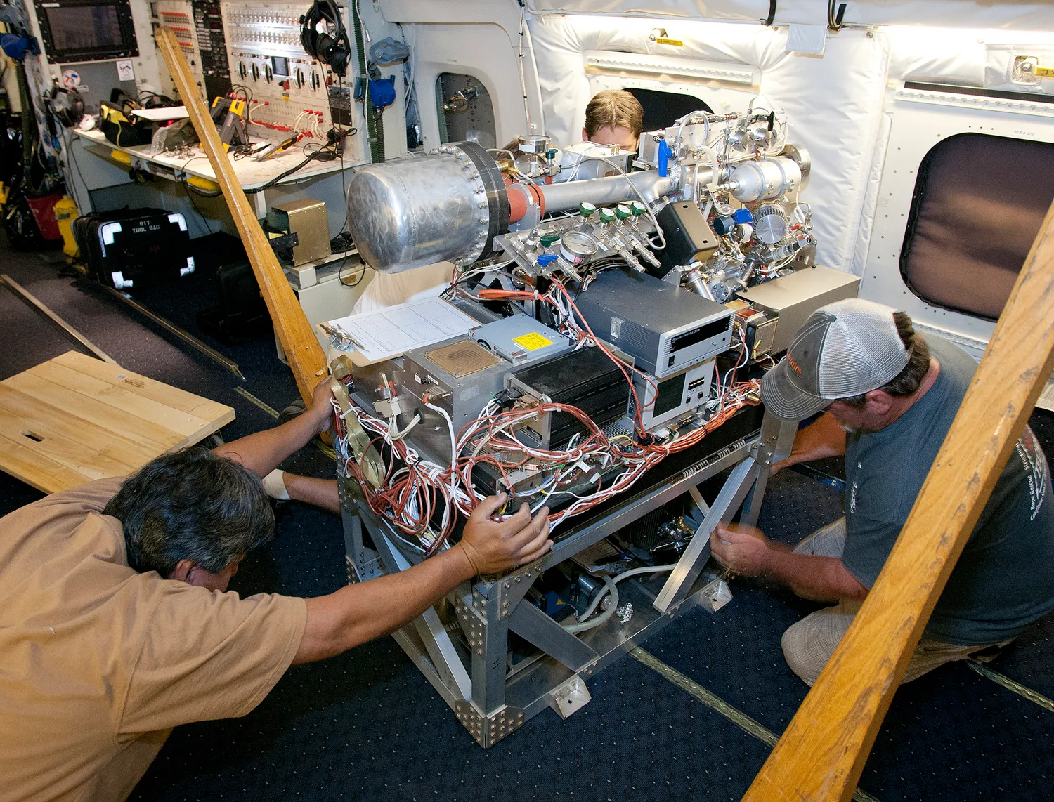 Scientists and technicians ready an instrument rack for mounting in NASA's DC-8 flying laboratory