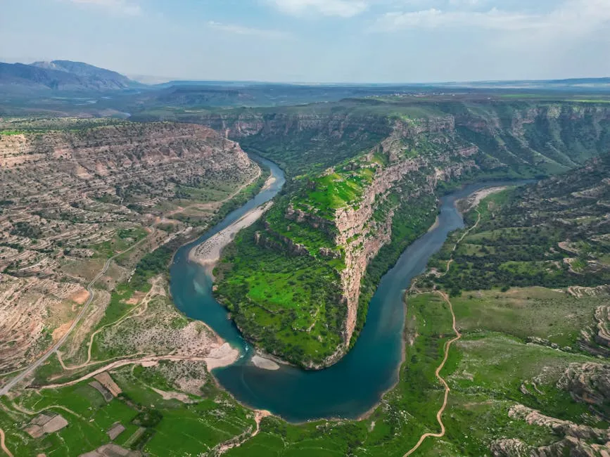 Stunning aerial view of the lush green Sulak Valley with meandering river in Şırnak, Türkiye.