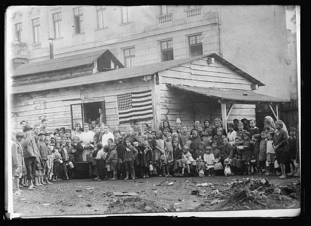 Where the great war started. In Sarajevo, province of Bosnia, the excuse for the Great War was made by the assassination of Archduke Ferdinand. It brought untold suffering and misery to the children of this country. Many died from starvation until the American Red Cross opened its feeding stations. Here are shown a group of school children about a Red Cross canteen in Sarajevo